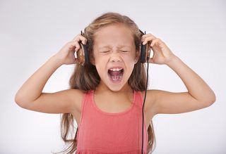 schreiendes Kind mit lauter Musik in Kopfhörern